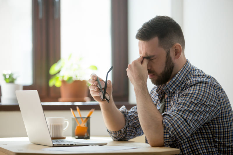 Hombre que está sintiendo estrés laboral 