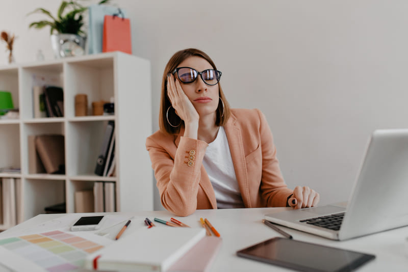 mujer cansada en el trabajo procrastinar concepto