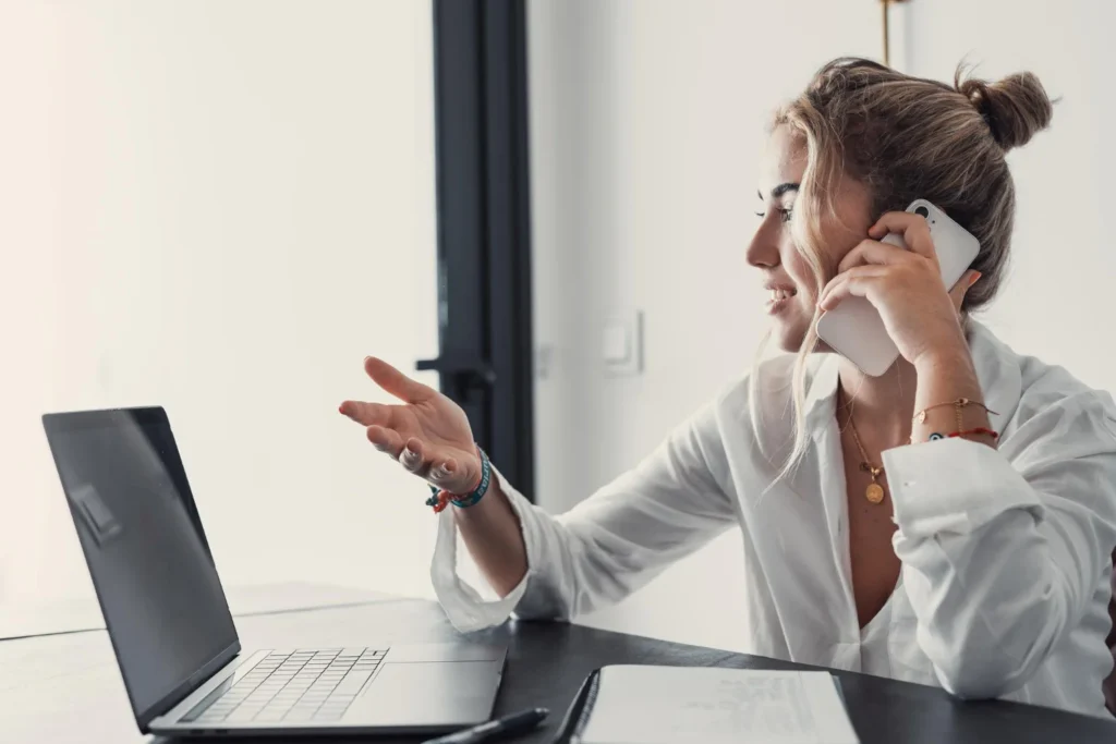 Mujer hablando por teléfono para atender una llamada de negocio